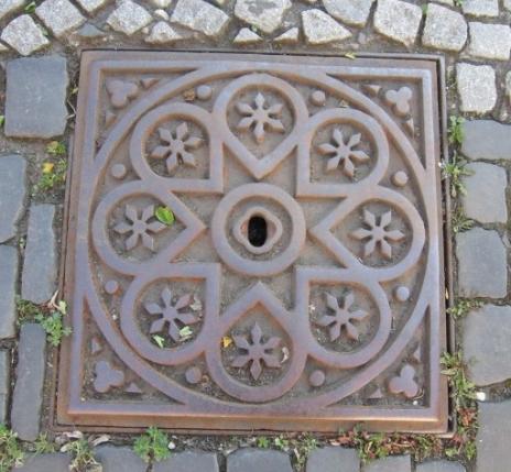 A photo of one of the manhole covers in The City of Bamberg which, along with the geomantic features of the city, inspired the artwork series "The Bamberg Mandalas".  Ein Foto von den Kanaldeckel die (zu den geomantische Eigenschaften der Stadt) den Bamberger Mandalas Kunstwerke mit inspiriert haben.