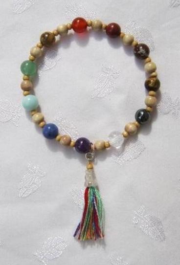 An example of a stone and wood bead chakra armband with a tassel.  Ein Beispiel von eine Stein- und Holzperlen Chakra Armband mit einen Bommel..